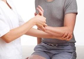 terapeuta comprobando estado muñeca paciente mujer