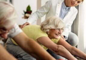 feliz pareja madura haciendo ejercicios estiramiento ayuda fisioterapeuta casa